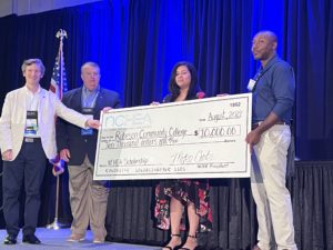 HVAC Scholarship winner holds check
