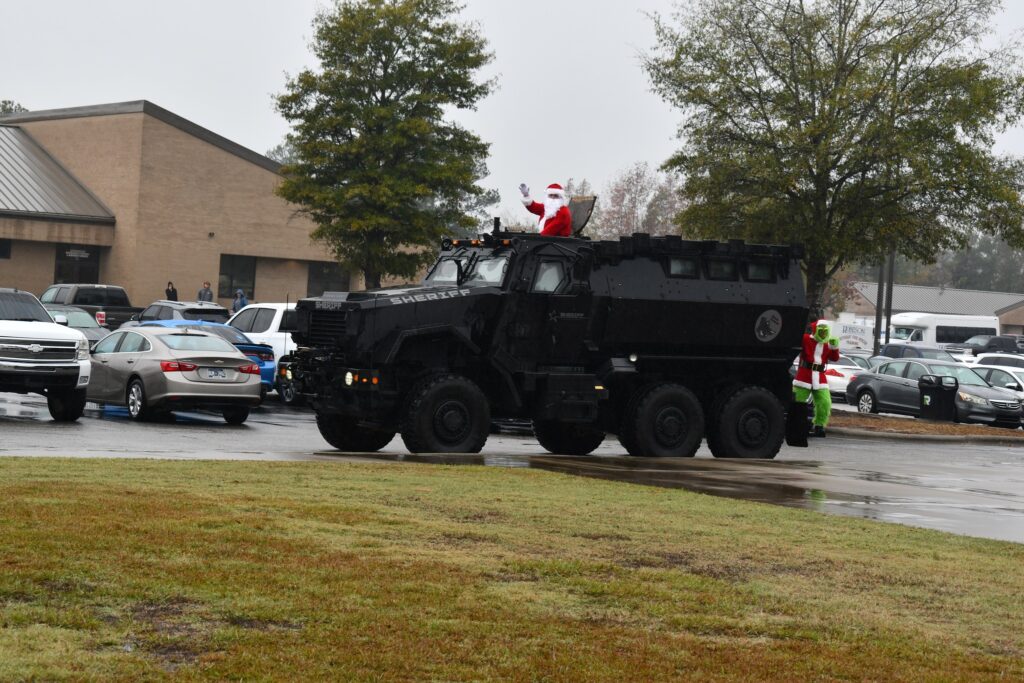 Santa visits RCC in armored police vehicle with grinch on the back