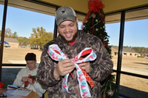 An Industrial Systems student takes a try at making a bow for his wreath during the free workshop at the Holiday Craft Fair.