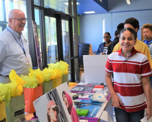 Middle schooler smiling at camera with vendor