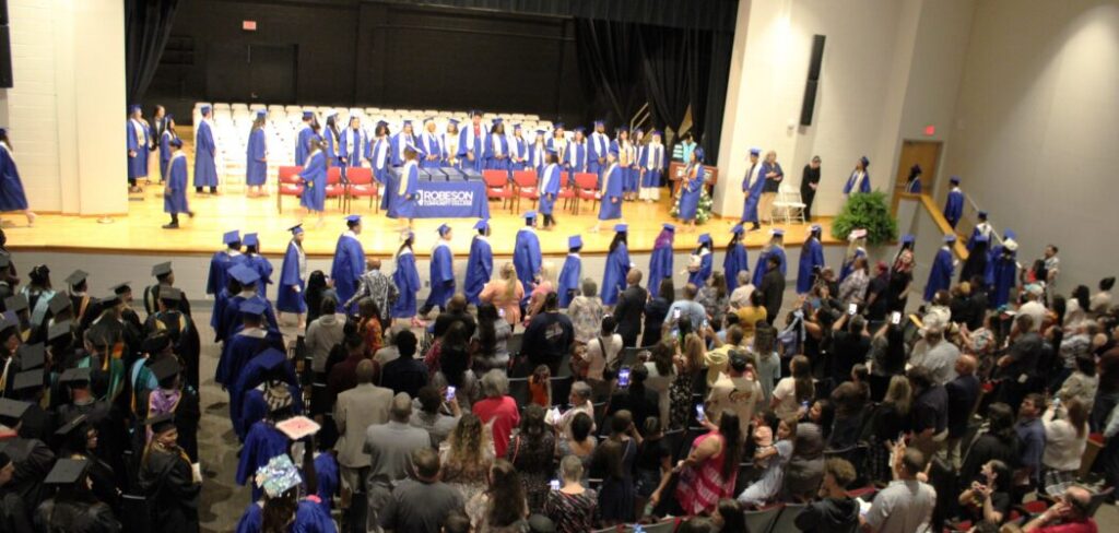 Graduates walking on stage to get their degrees