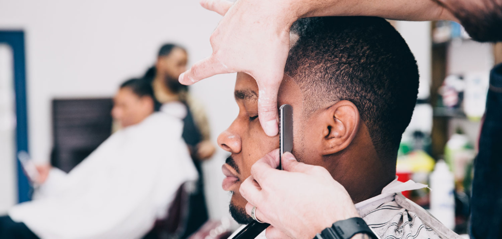 Man shaving mans face