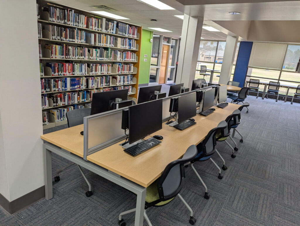 Library computer table adjacent to a book stack