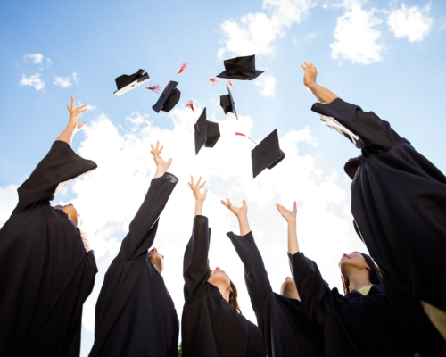 Graduates throwing caps into the air