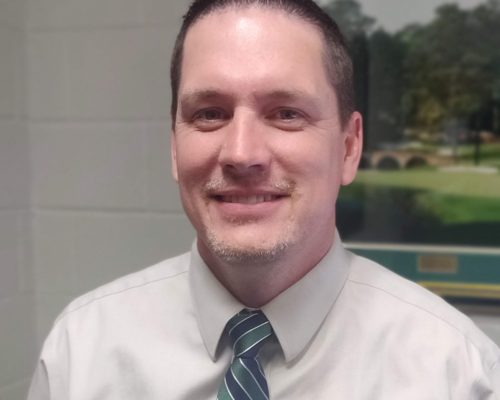 a man smiling into the camera with a tie on